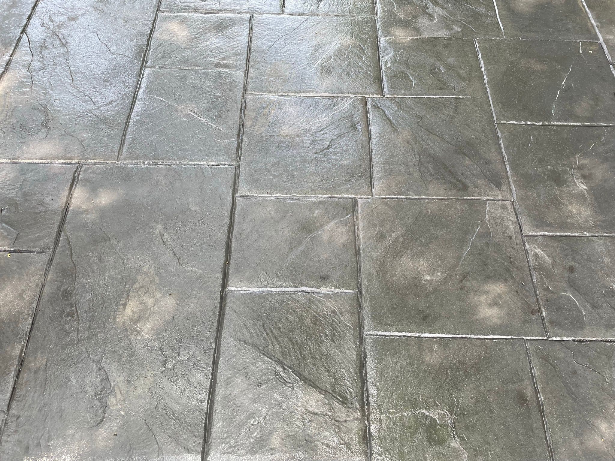 Grey large ashlar imprinted concrete, stamped as broad riven slate slabs with fine joint lines